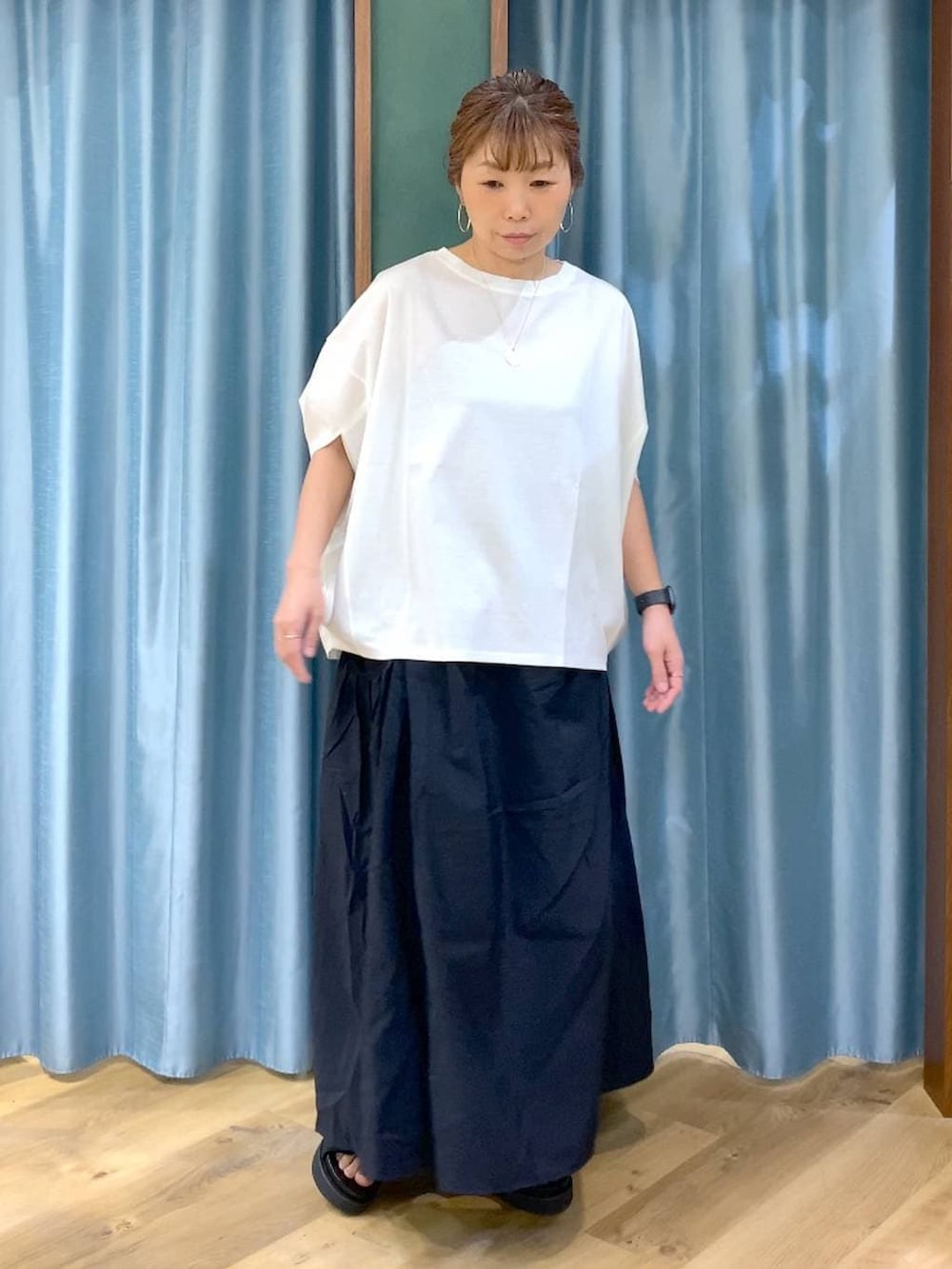 ホワイト系のTシャツ/カットソー、ブラック系のスカート、ブラック系のサンダルを着用したレディースの春コーディネートの2枚目の写真