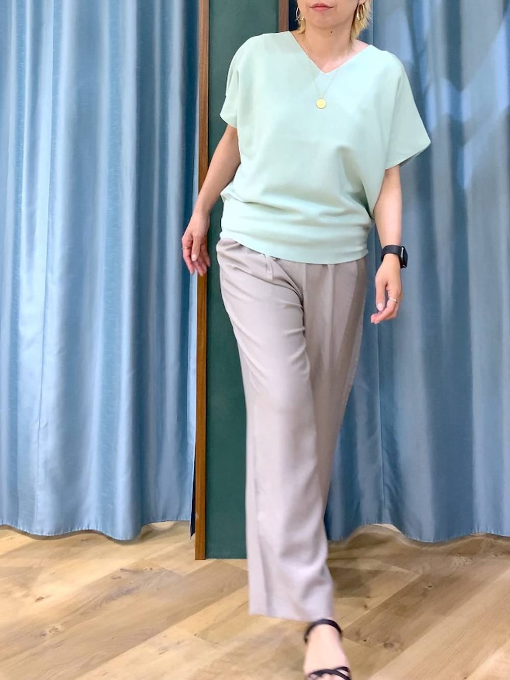 グリーン系のニット/セーター、ベージュ系のその他パンツ、ブラック系のサンダルを着用したレディースの春コーディネートの5枚目の写真