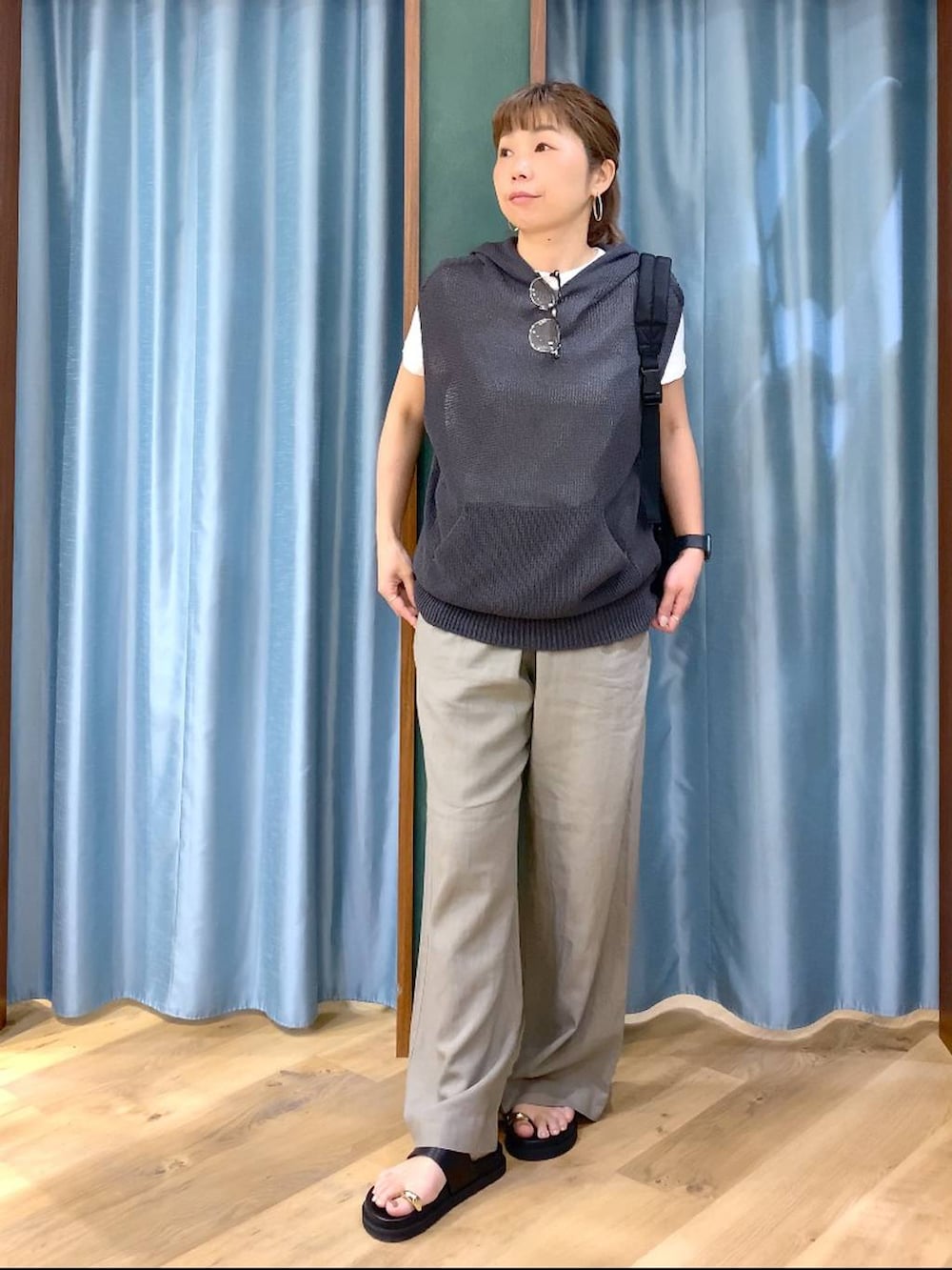 グレー系のニット/セーター、ブラウン系のその他パンツ、ブラック系のサンダルを着用したレディースの春コーディネートの2枚目の写真