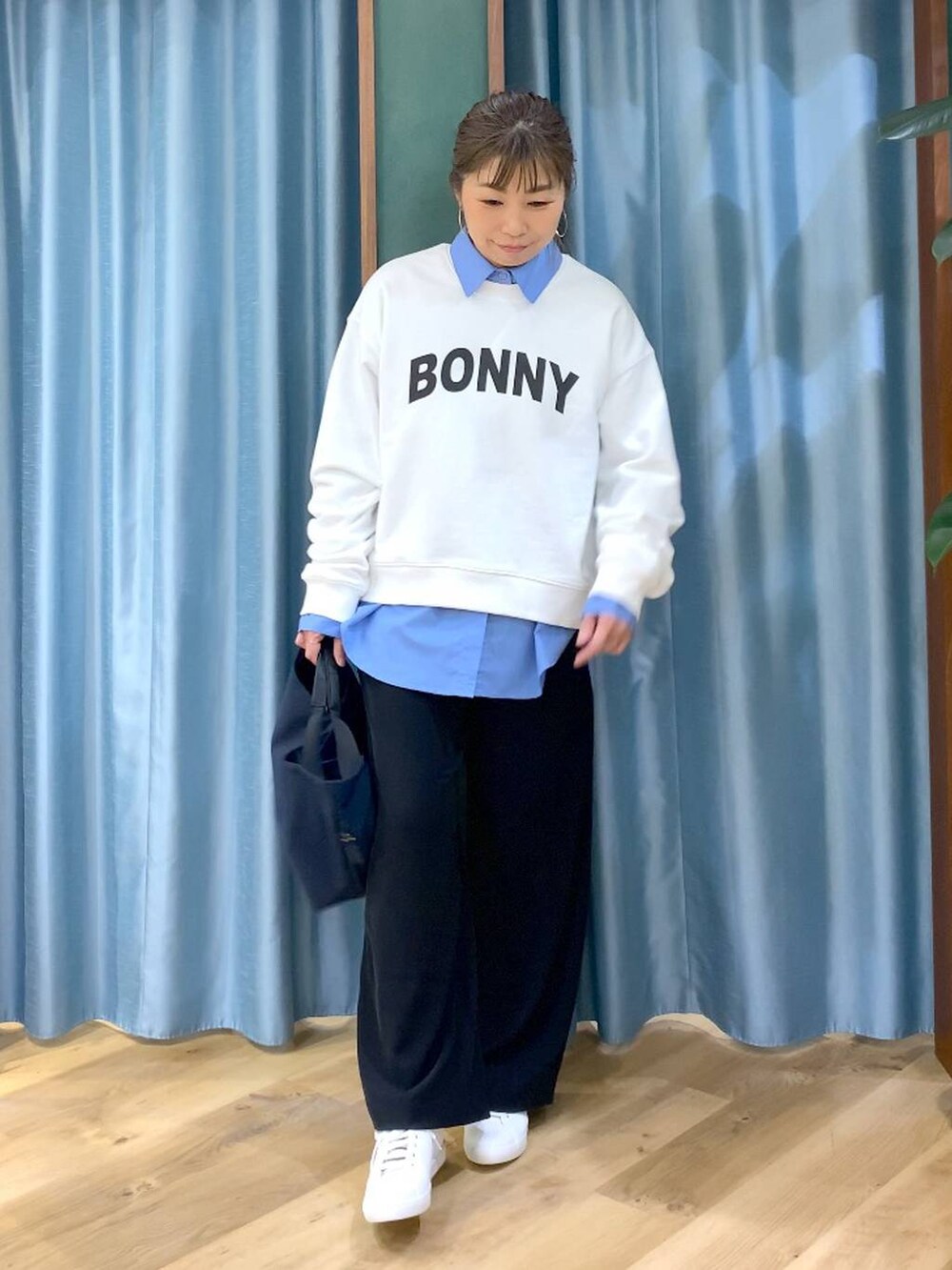 ブラック系のスラックス、ブルー系のトートバッグ、ブルー系のシャツ/ブラウスを着用したレディースの冬コーディネートの6枚目の写真