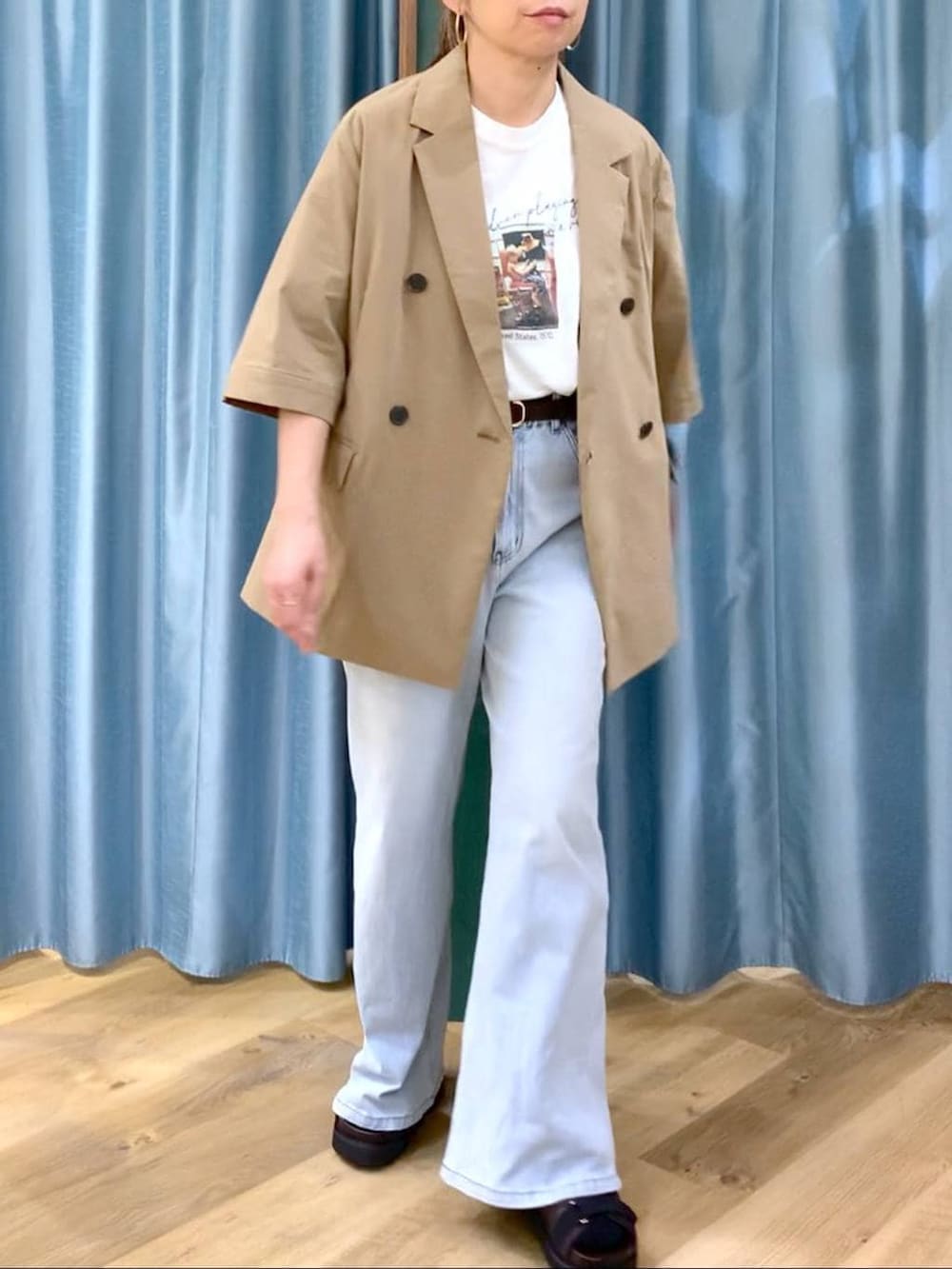 ブルー系のデニムパンツ、ホワイト系のTシャツ/カットソー、ブラウン系のサンダルを着用したレディースの春コーディネートの7枚目の写真