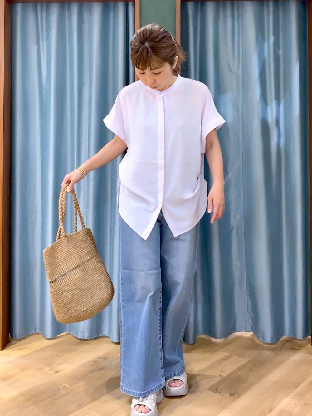 ブルー系のデニムパンツ、ブルー系のシャツ/ブラウス、グレー系のサンダルを着用したレディースの春コーディネートの3枚目の写真