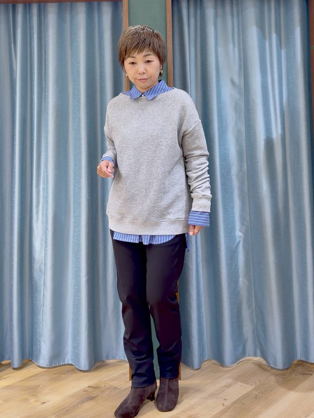 ブラック系のその他パンツ、ブラウン系のブーツ、ブルー系のシャツ/ブラウスを着用したレディースの秋コーディネートの2枚目の写真