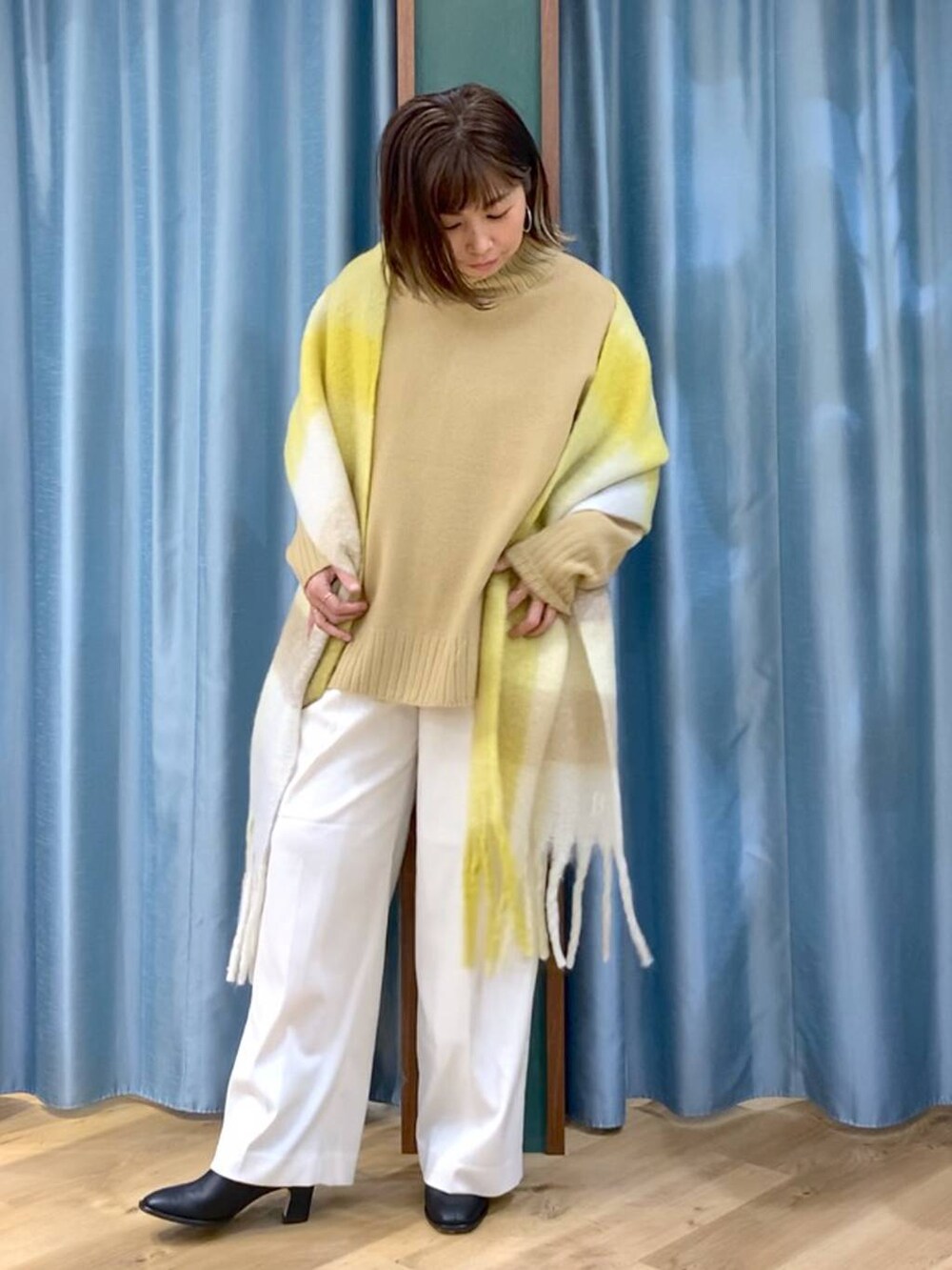 ベージュ系のニット/セーター、ブラック系のブーツ、ホワイト系のその他パンツを着用したレディースの秋コーディネートの3枚目の写真