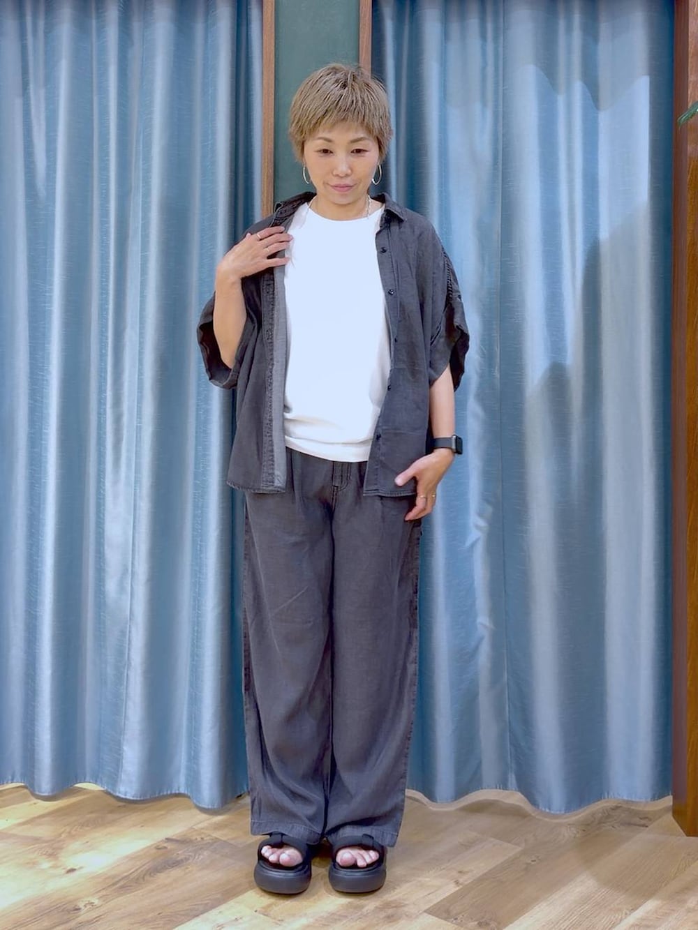 ブラック系のサンダル、ホワイト系のTシャツ/カットソー、ブラック系のシャツ/ブラウスを着用したレディースの夏コーディネートの2枚目の写真