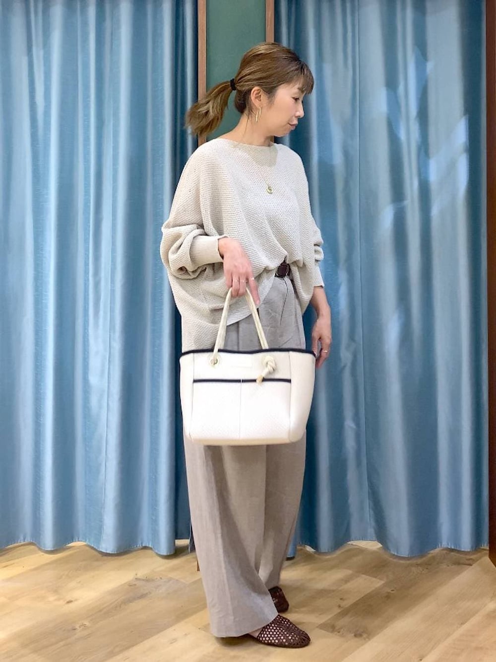 ベージュ系のニット/セーター、ホワイト系のトートバッグ、ベージュ系のその他パンツを着用したレディースの春コーディネートの4枚目の写真