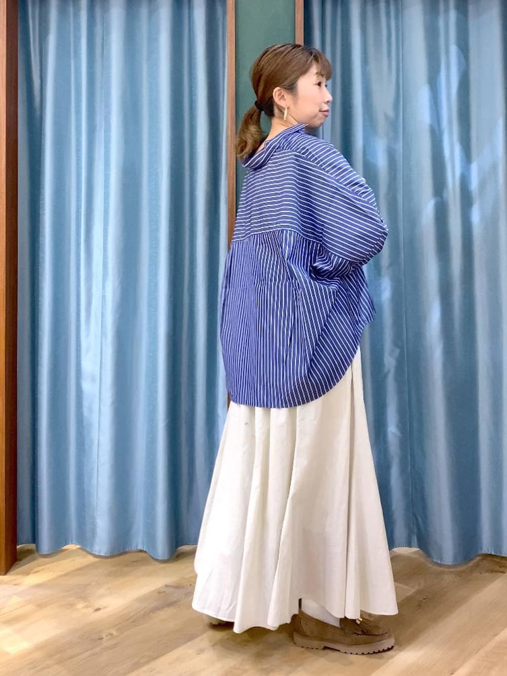 ベージュ系のローファー、ホワイト系のスカート、ブルー系のシャツ/ブラウスを着用したレディースの春コーディネートの4枚目の写真