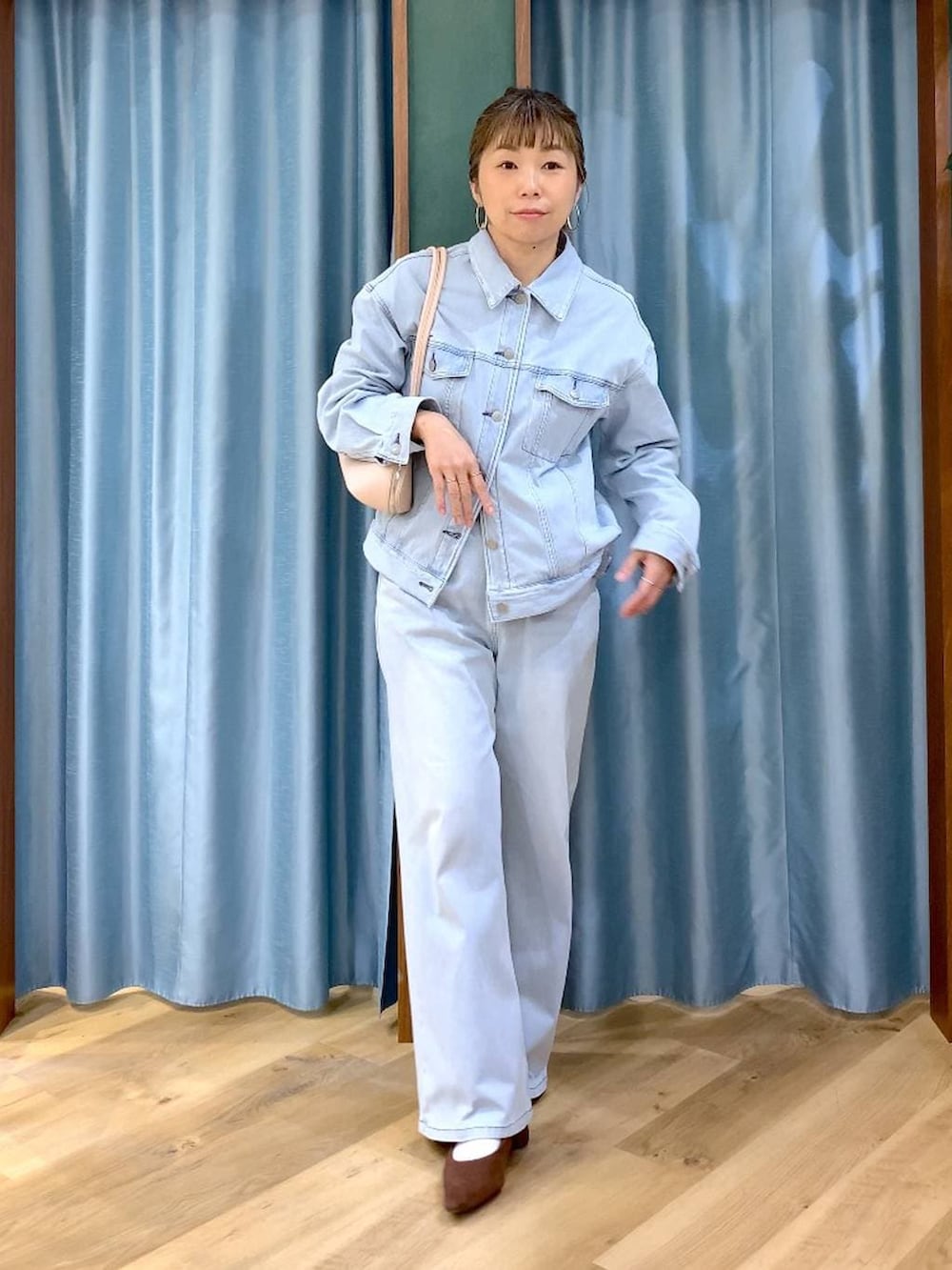 ブラウン系のパンプス、ブルー系のデニムパンツ、ブルー系のデニムジャケットを着用したレディースの春コーディネートの3枚目の写真