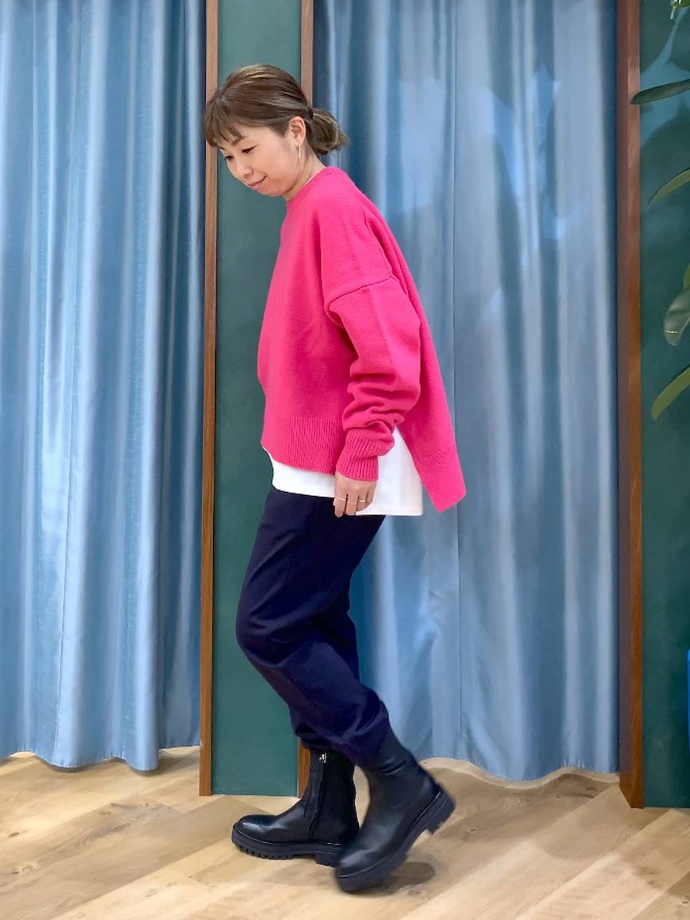 ブラック系のブーツ、ブルー系のその他パンツ、ピンク系のニット/セーターを着用したレディースの冬コーディネートの2枚目の写真