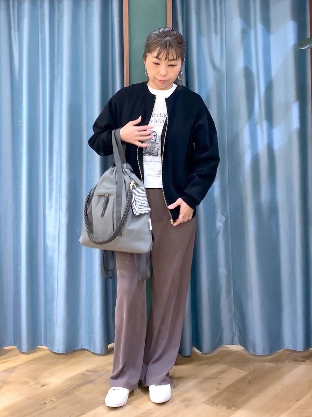 グリーン系のスラックス、ブラック系のカーディガン/ボレロ、グレー系のバックパック/リュックを着用したレディースの冬コーディネートの3枚目の写真