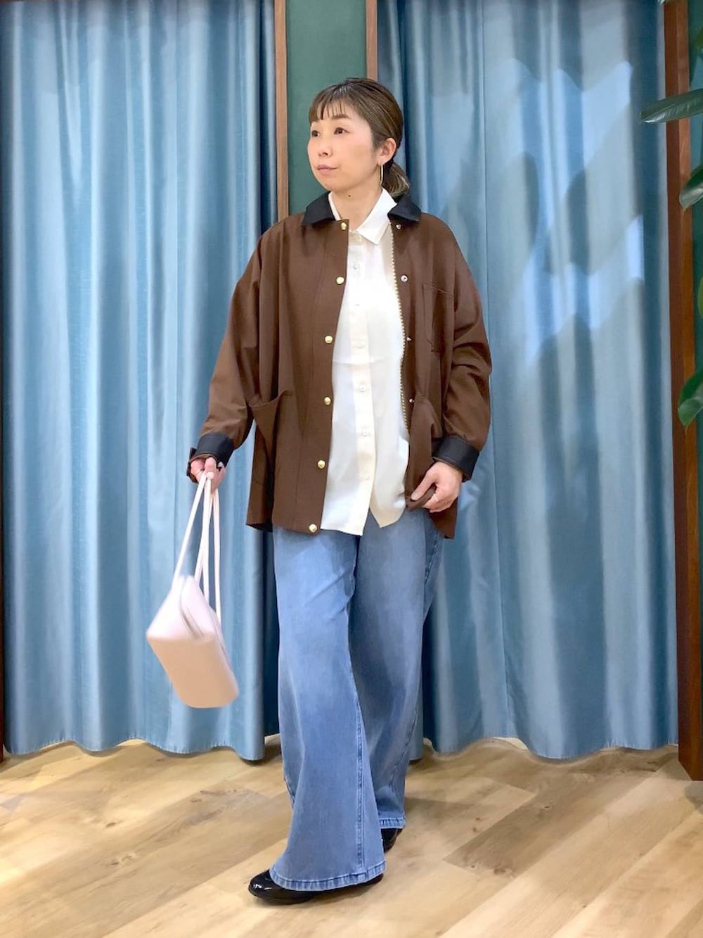 ブルー系のデニムパンツ、ブラウン系のカバーオール、ブラック系のローファーを着用したレディースの冬コーディネートの3枚目の写真