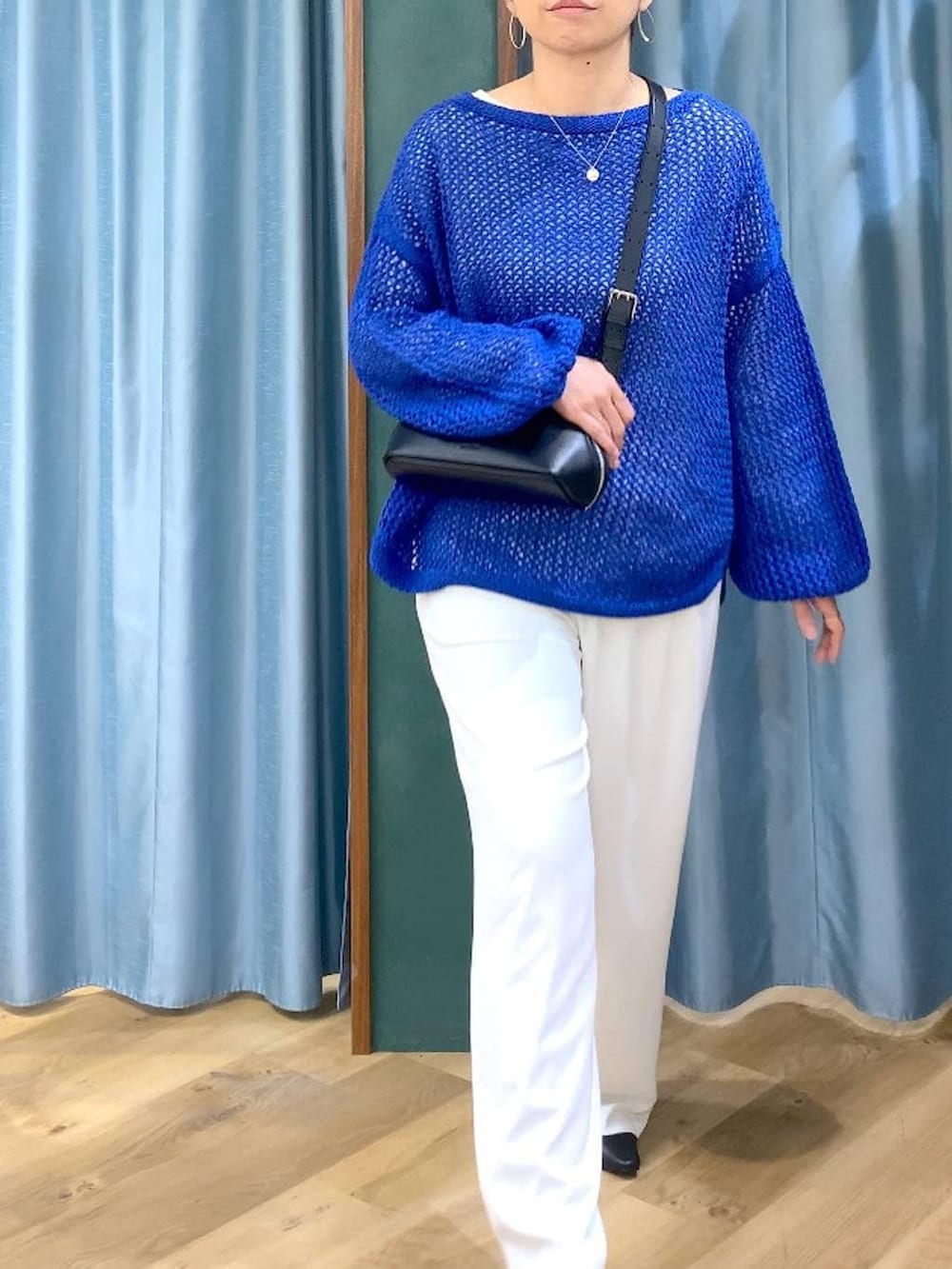 ホワイト系のスラックス、ブルー系のニット/セーター、ブラック系のパンプスを着用したレディースの冬コーディネートの7枚目の写真