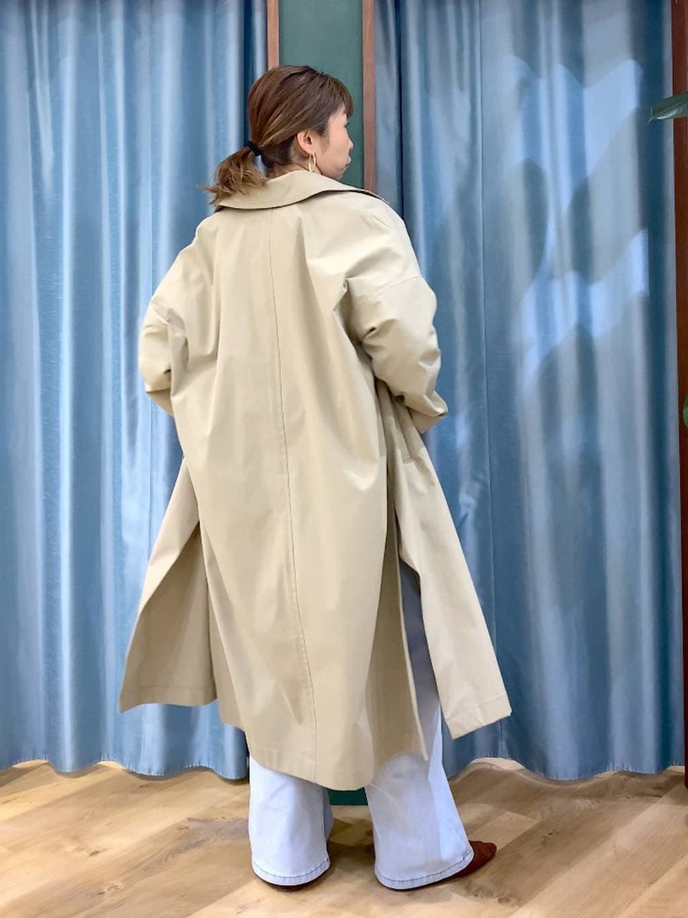 ブラウン系のパンプス、ブルー系のデニムパンツ、グリーン系のニット/セーターを着用したレディースの冬コーディネートの5枚目の写真