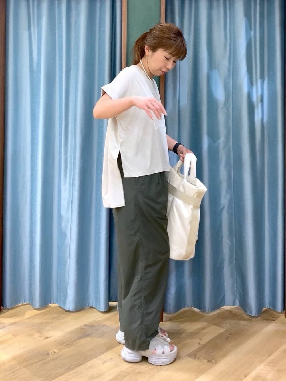 グリーン系のその他パンツ、ホワイト系のトートバッグ、グレー系のサンダルを着用したレディースの春コーディネートの4枚目の写真