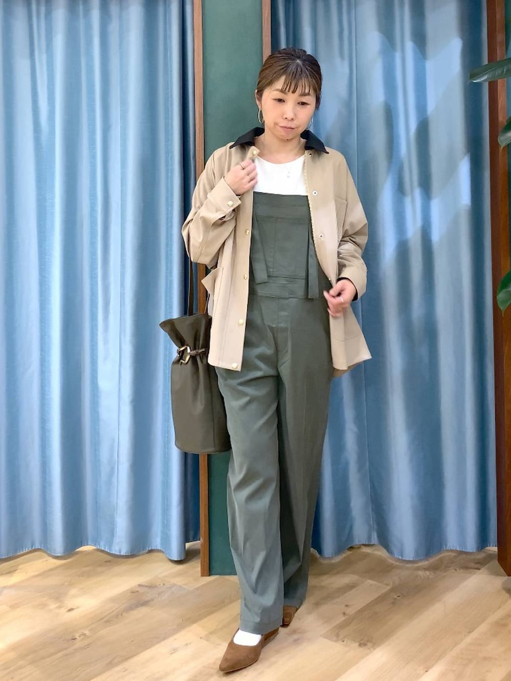 グリーン系のサロペット/オーバーオール、ベージュ系のカバーオール、ホワイト系のTシャツ/カットソーを着用したレディースの冬コーディネートの3枚目の写真