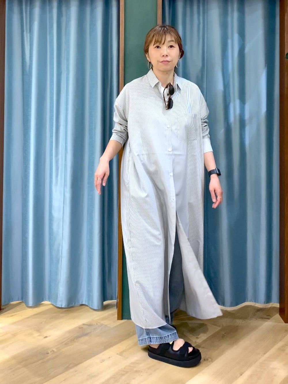 ブラック系のワンピース、ブルー系のデニムパンツ、ブラック系のサンダルを着用したレディースの春コーディネートの4枚目の写真