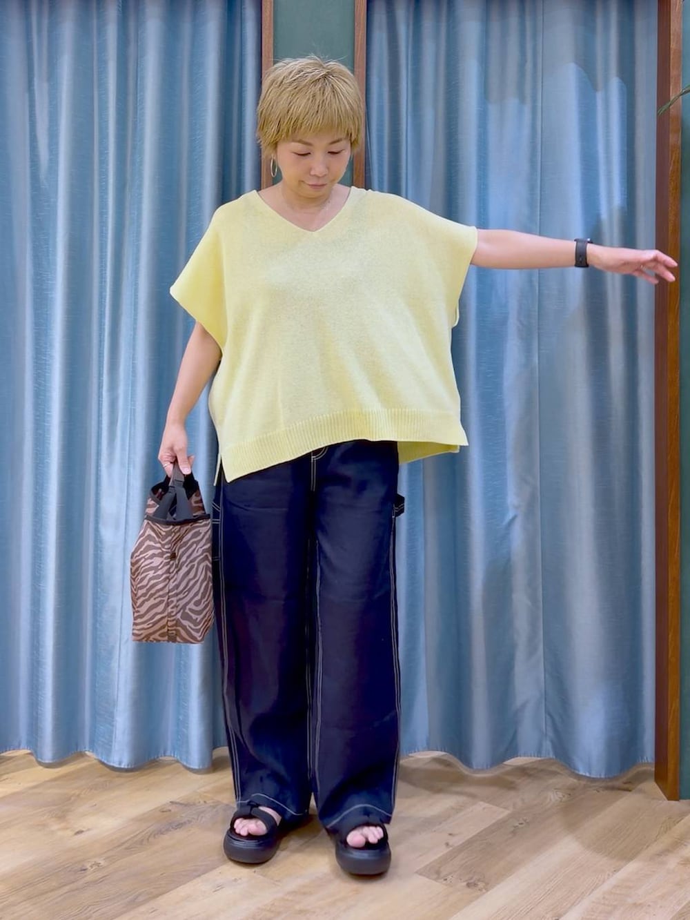 ブラウン系のトートバッグ、ブルー系のその他パンツ、ブラック系のサンダルを着用したレディースの夏コーディネートの6枚目の写真