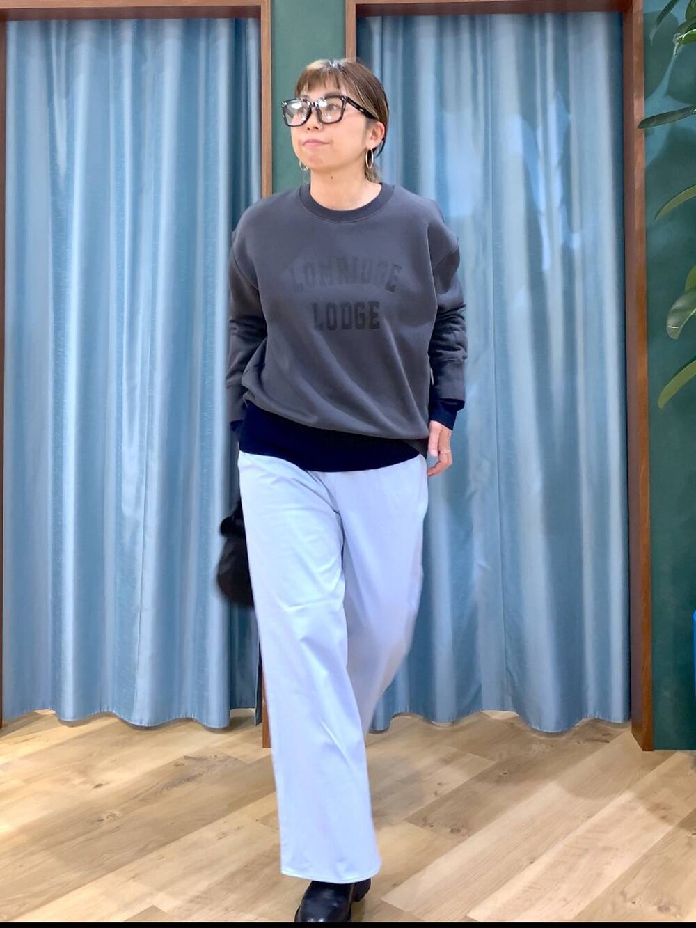 ブラック系のブーツ、ブラック系のショルダーバッグ、ブルー系のニット/セーターを着用したレディースの秋コーディネートの6枚目の写真