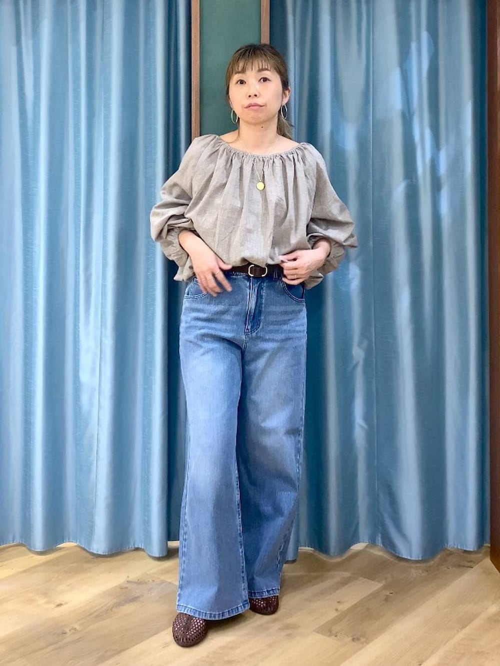 ブルー系のデニムパンツ、ベージュ系のシャツ/ブラウス、ブラウン系のスリッポンを着用したレディースの春コーディネートの3枚目の写真