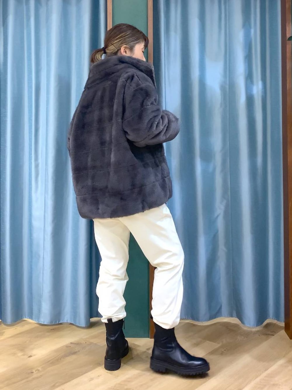 ブラック系のブーツ、グレー系のブルゾン、ホワイト系のその他パンツを着用したレディースの秋コーディネートの3枚目の写真