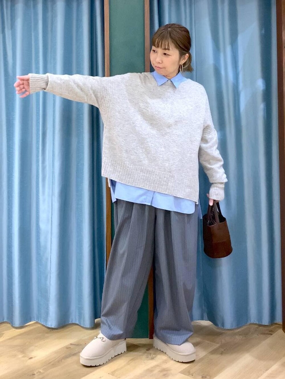 ブルー系のシャツ/ブラウス、ベージュ系のスリッポン、ベージュ系のニット/セーターを着用したレディースの冬コーディネートの7枚目の写真