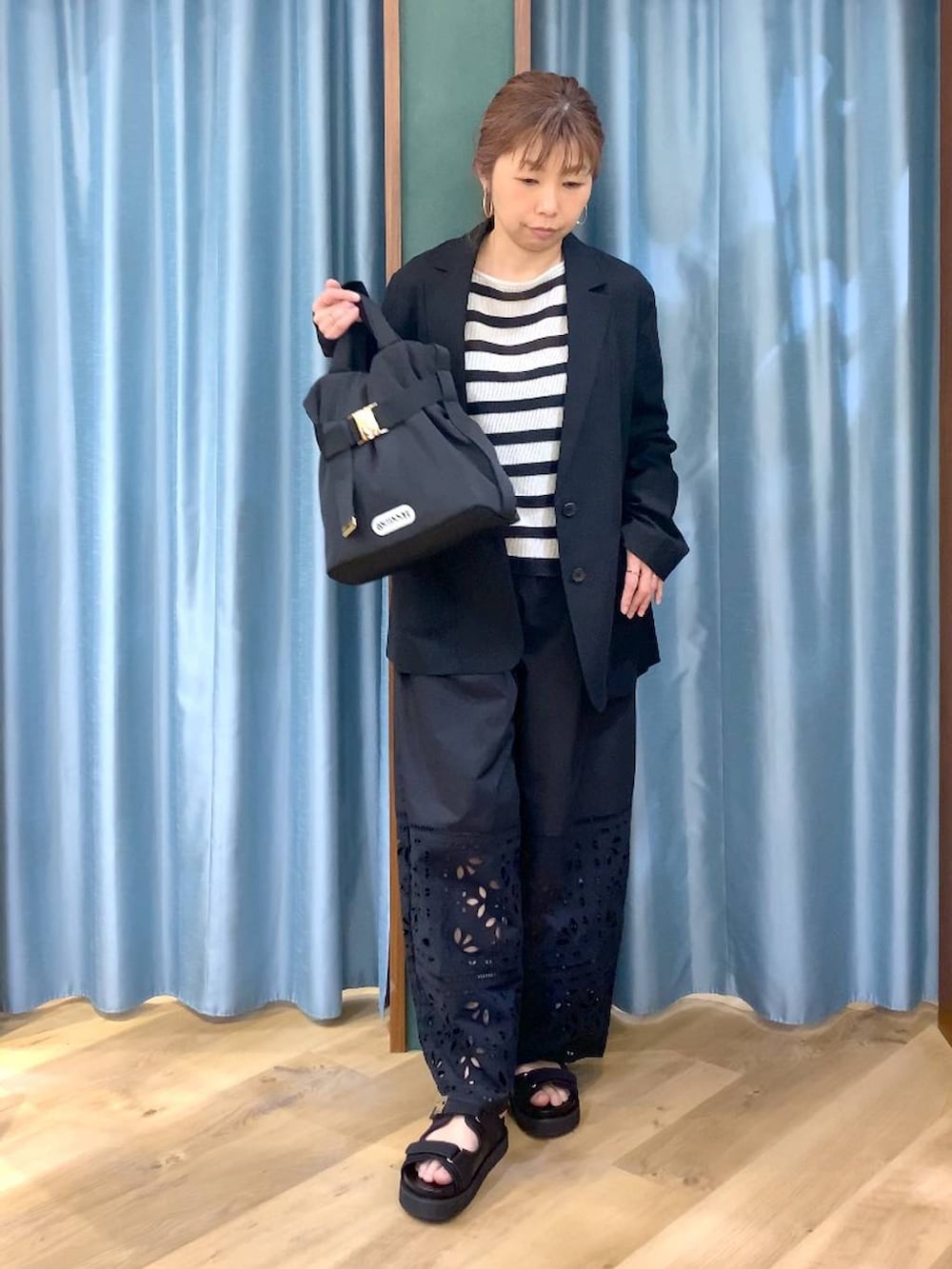 ベージュ系のニット/セーター、ブラック系のテーラードジャケット、ブラック系のその他パンツを着用したレディースの春コーディネートの2枚目の写真