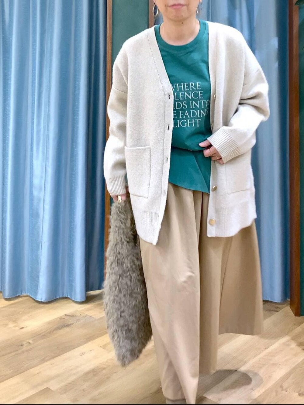 ベージュ系のハンドバッグ、ベージュ系のブーツ、グリーン系のTシャツ/カットソーを着用したレディースの冬コーディネートの7枚目の写真