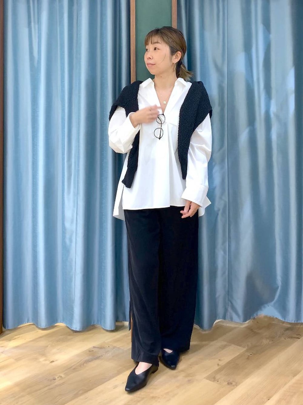 ブラック系のスラックス、ブラック系のカーディガン/ボレロ、ブラック系のパンプスを着用したレディースの春コーディネートの3枚目の写真