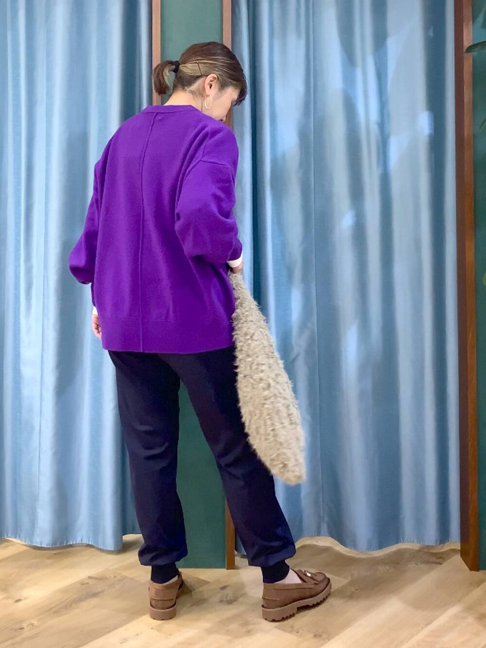 パープル系のニット/セーター、ベージュ系のハンドバッグ、ブルー系のその他パンツを着用したレディースの秋コーディネートの3枚目の写真