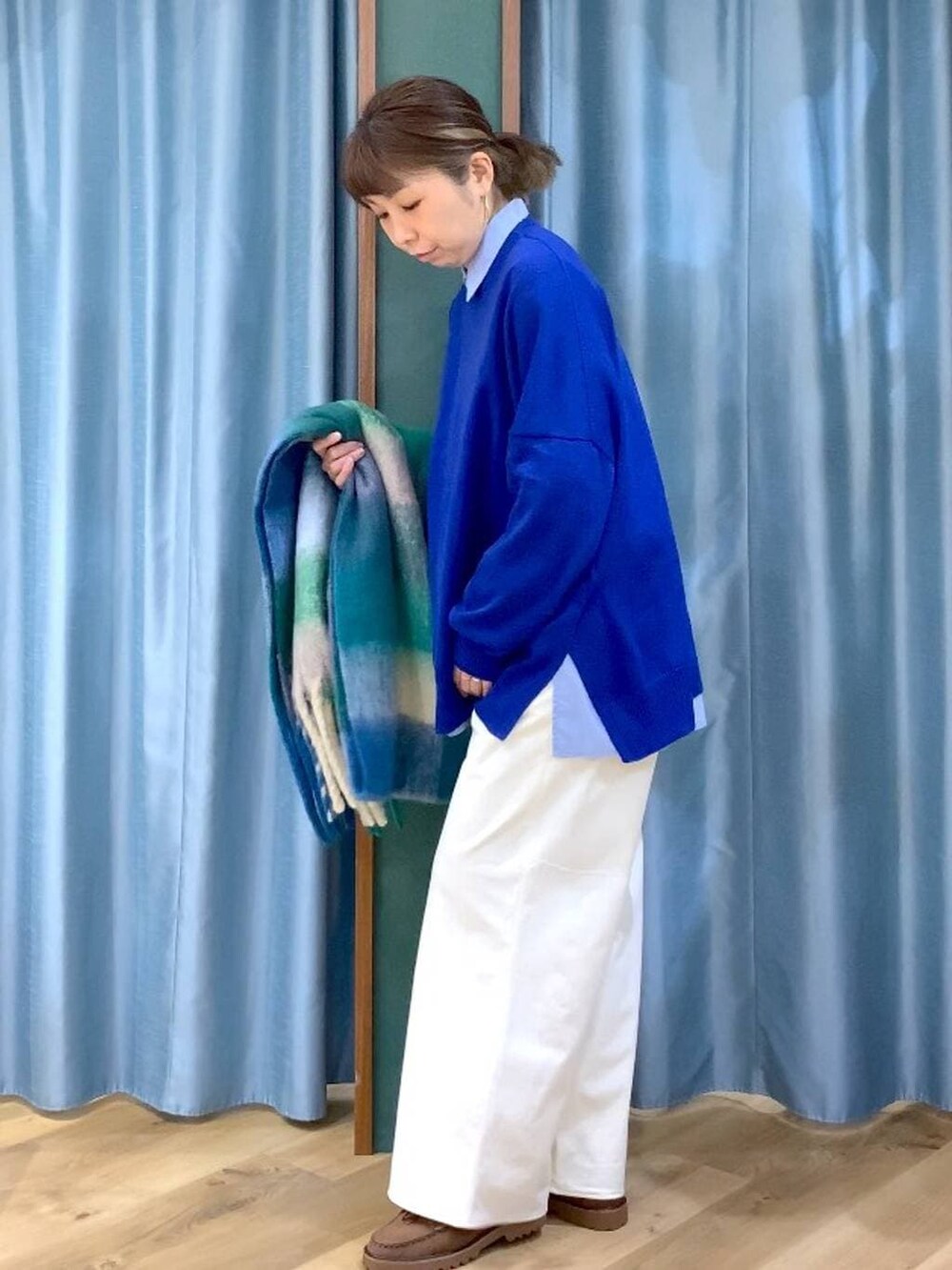 ブルー系のシャツ/ブラウス、ブラウン系のローファー、ブルー系のニット/セーターを着用したレディースの秋コーディネートの2枚目の写真