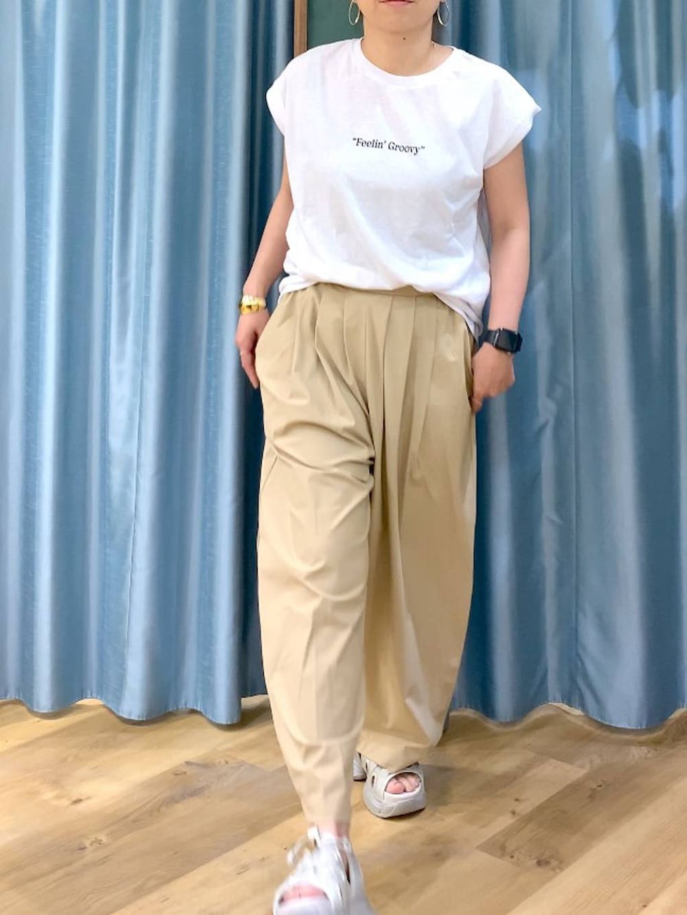 ベージュ系のその他パンツ、ホワイト系のTシャツ/カットソー、グレー系のサンダルを着用したレディースの春コーディネートの7枚目の写真