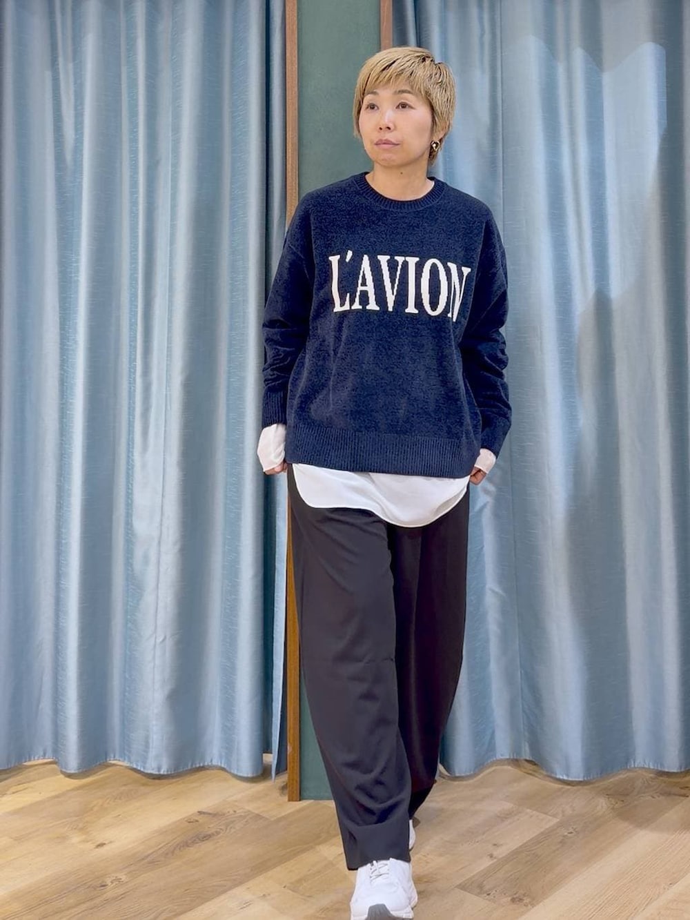 ブルー系のニット/セーター、ホワイト系のTシャツ/カットソー、ブラック系のその他パンツを着用したレディースの秋コーディネートの2枚目の写真