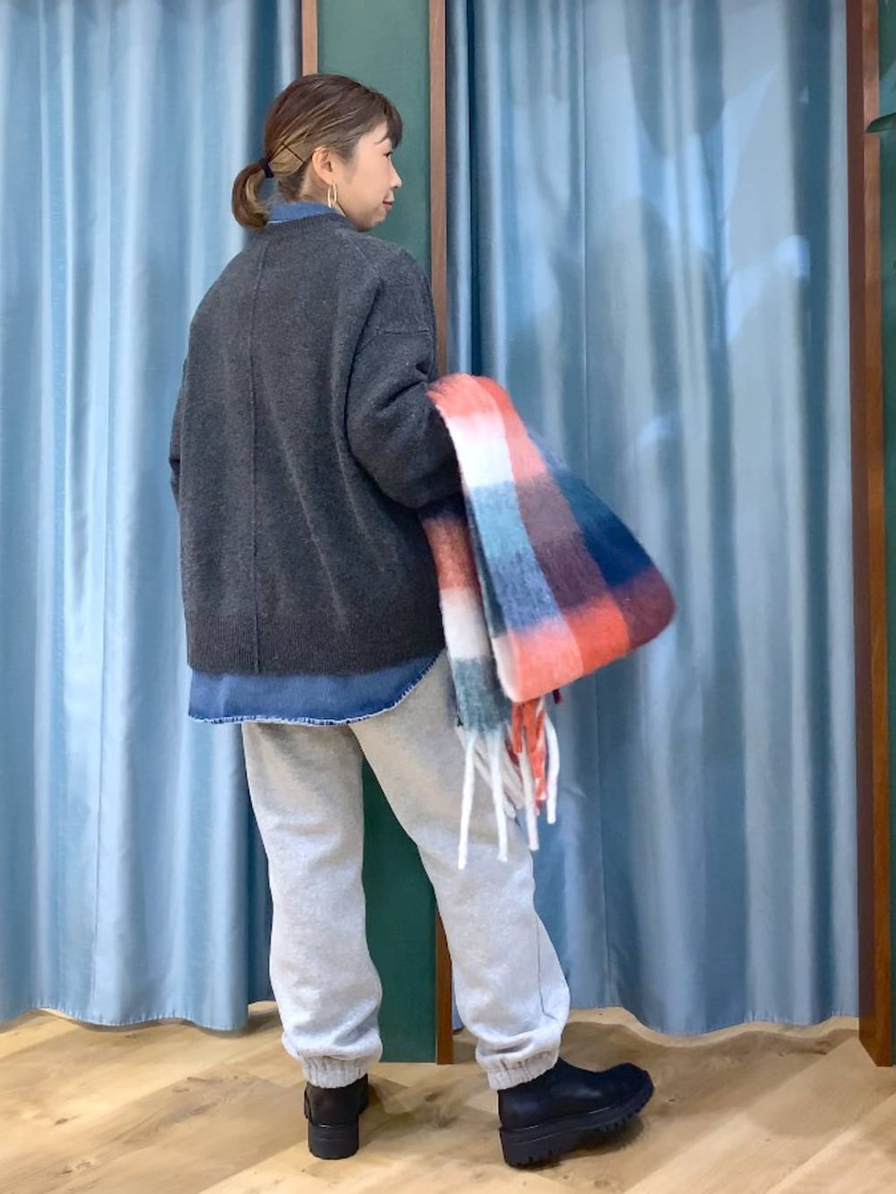 ブラック系のブーツ、ブルー系のシャツ/ブラウス、グレー系のニット/セーターを着用したレディースの秋コーディネートの5枚目の写真