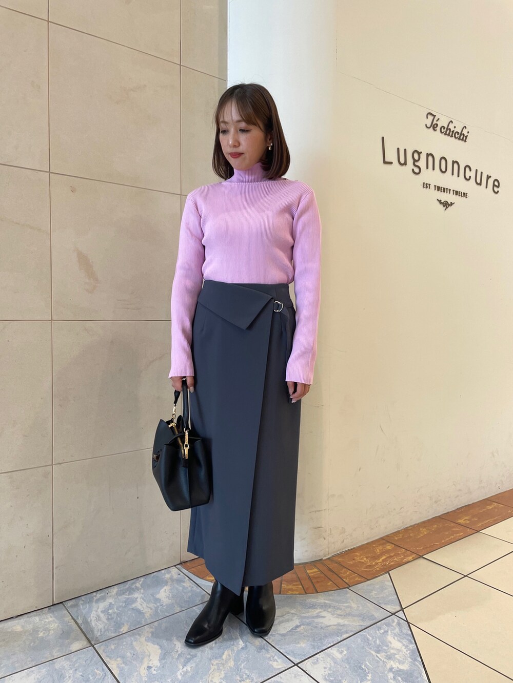 ピンク系のニット/セーター、グレー系のスカートを着用したレディースの秋コーディネートの2枚目の写真