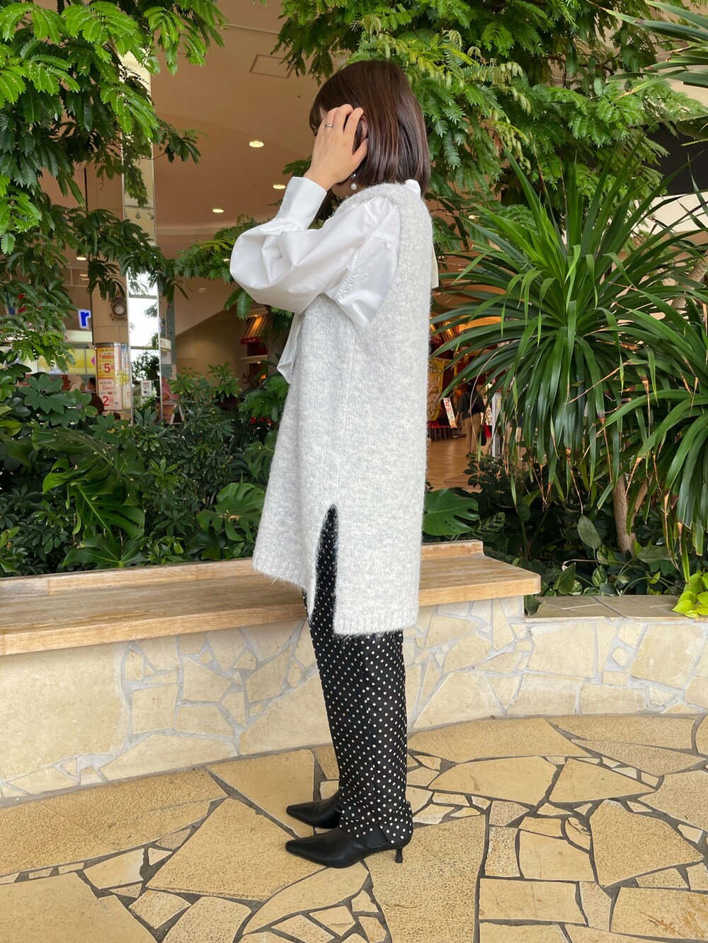 ホワイト系のシャツ/ブラウス、グレー系のニット/セーターを着用したレディースの秋コーディネートの2枚目の写真