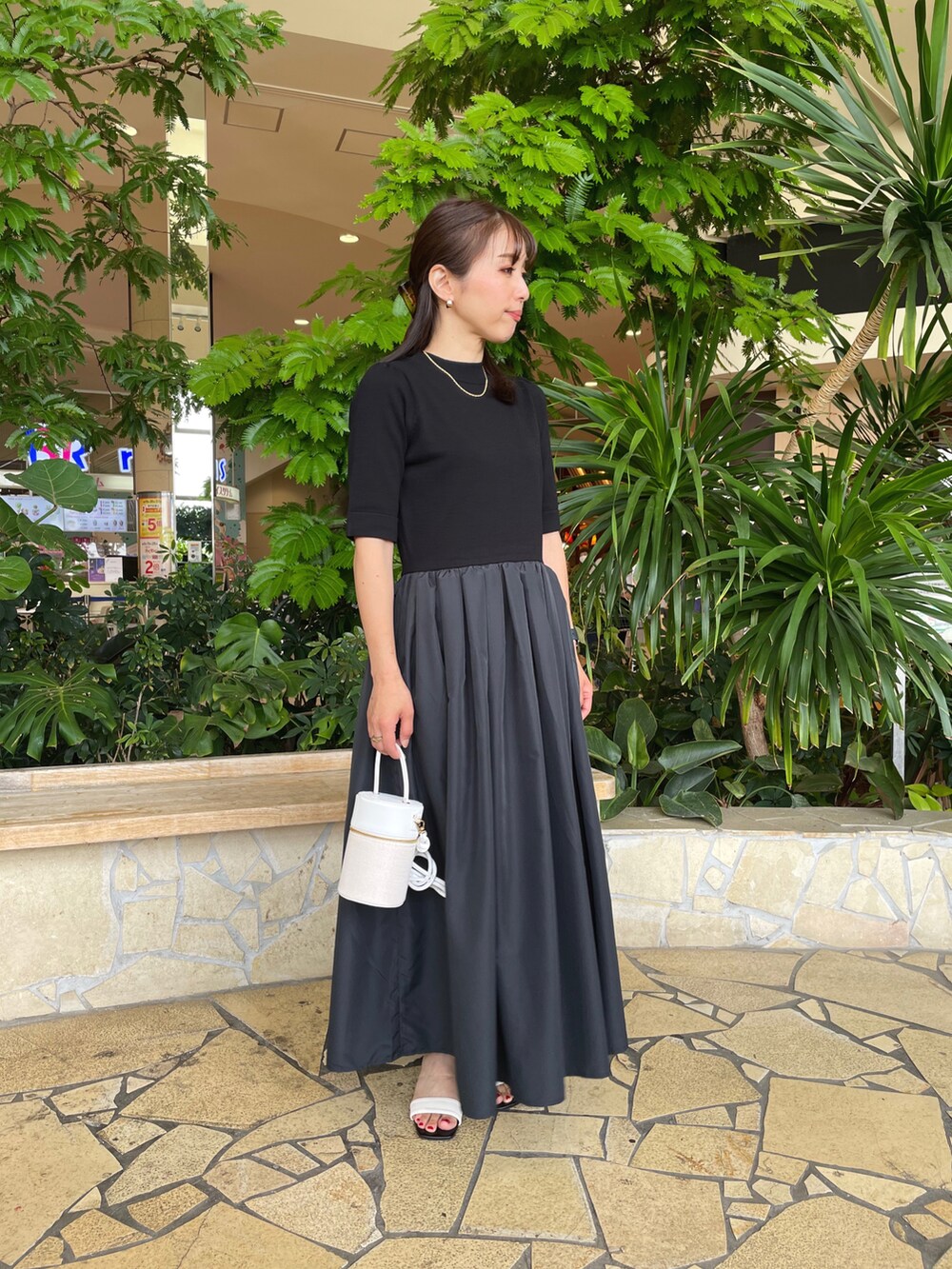 ブラック系のワンピースを着用したレディースの夏コーディネートの2枚目の写真