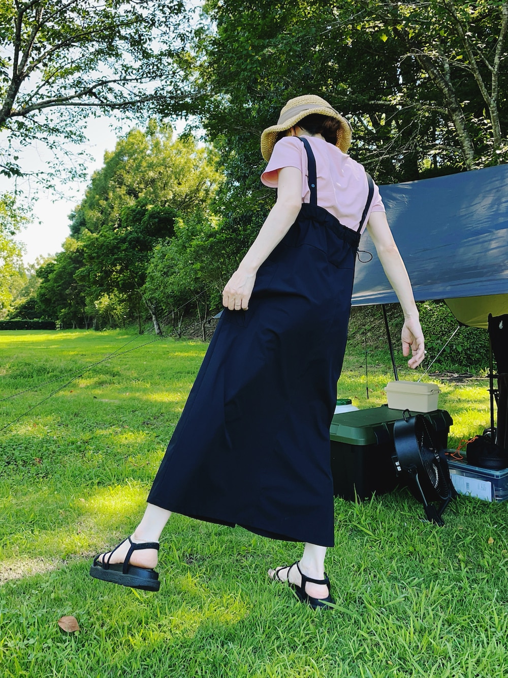 ブラック系のサンダル、ブラック系のジャンパースカート、ピンク系のTシャツ/カットソーを着用したレディースの夏コーディネートの2枚目の写真