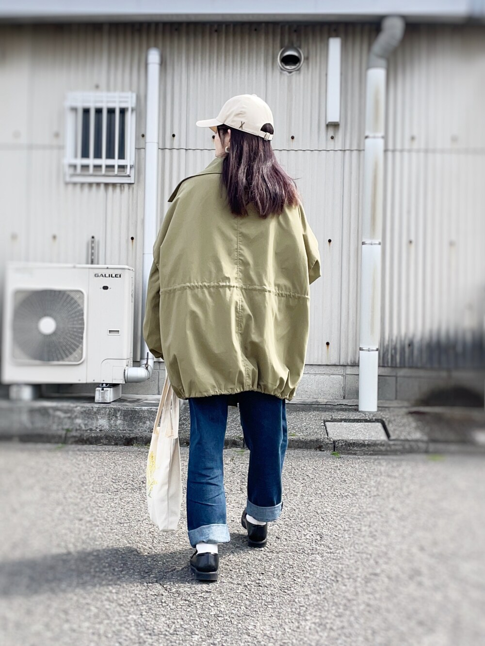グリーン系のモッズコート、ホワイト系のTシャツ/カットソー、ホワイト系のトートバッグを着用したレディースの春コーディネートの2枚目の写真