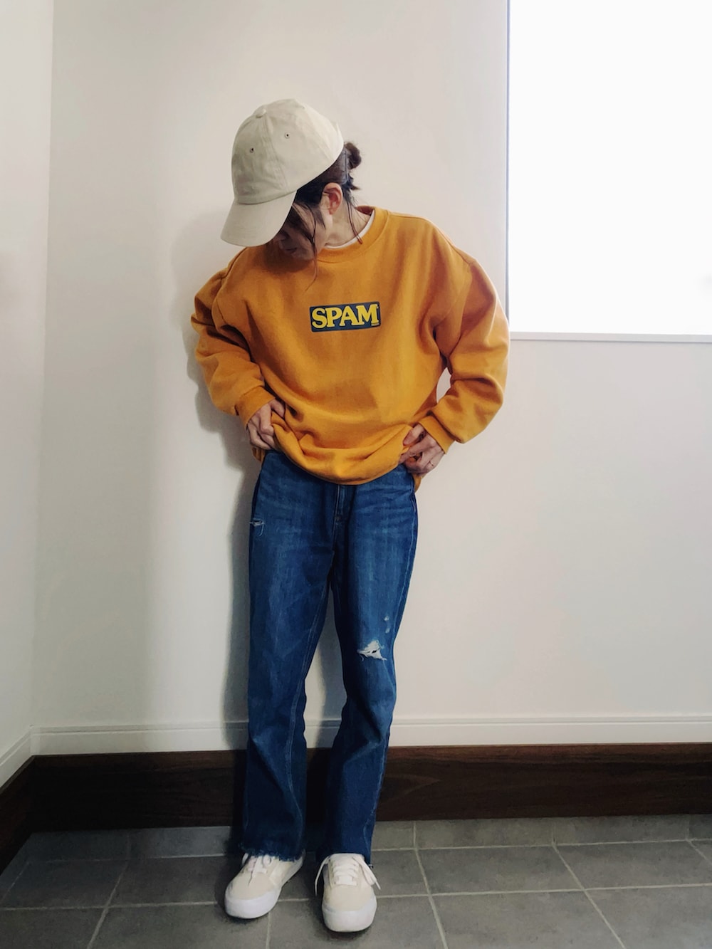 ブルー系のデニムパンツ、ホワイト系のスニーカー、イエロー系のスウェットを着用したレディースの冬コーディネートの2枚目の写真