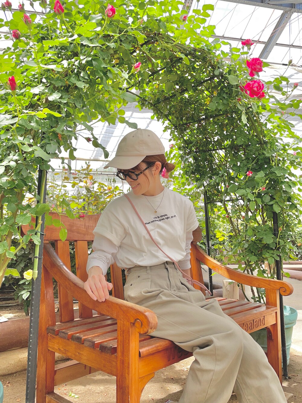 ホワイト系のTシャツ/カットソー、ピンク系のショルダーバッグ、グリーン系のデニムパンツを着用したレディースの春コーディネートの2枚目の写真