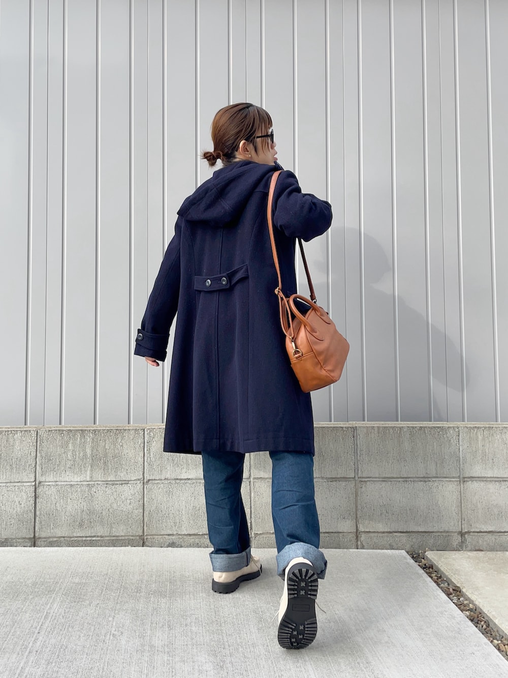 ブルー系のデニムパンツ、ベージュ系のドレスシューズ、ホワイト系のベストを着用したレディースの冬コーディネートの2枚目の写真