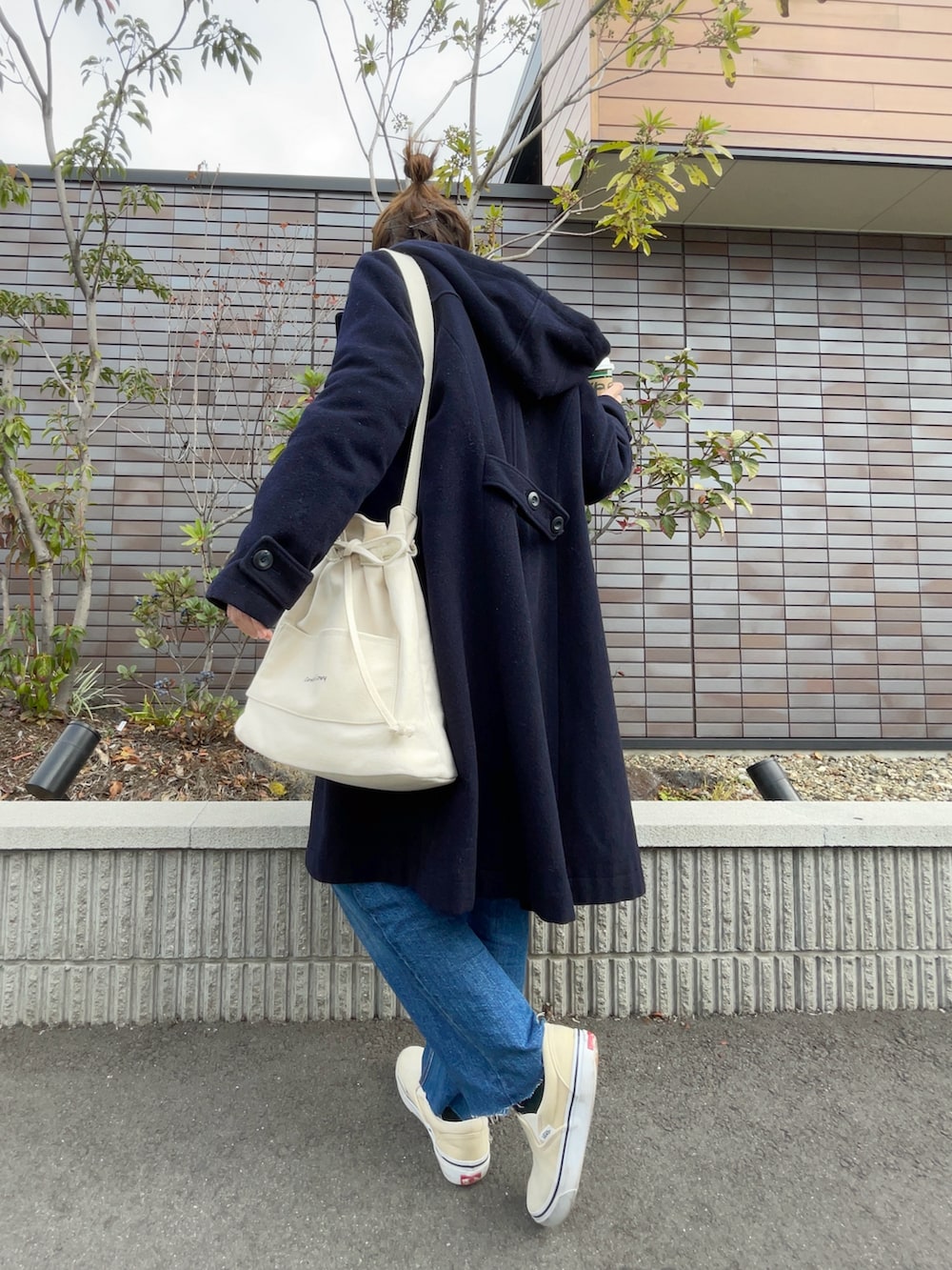 ブルー系のデニムパンツ、ホワイト系のカーディガン/ボレロ、ブルー系のシャツ/ブラウスを着用したレディースの冬コーディネートの2枚目の写真