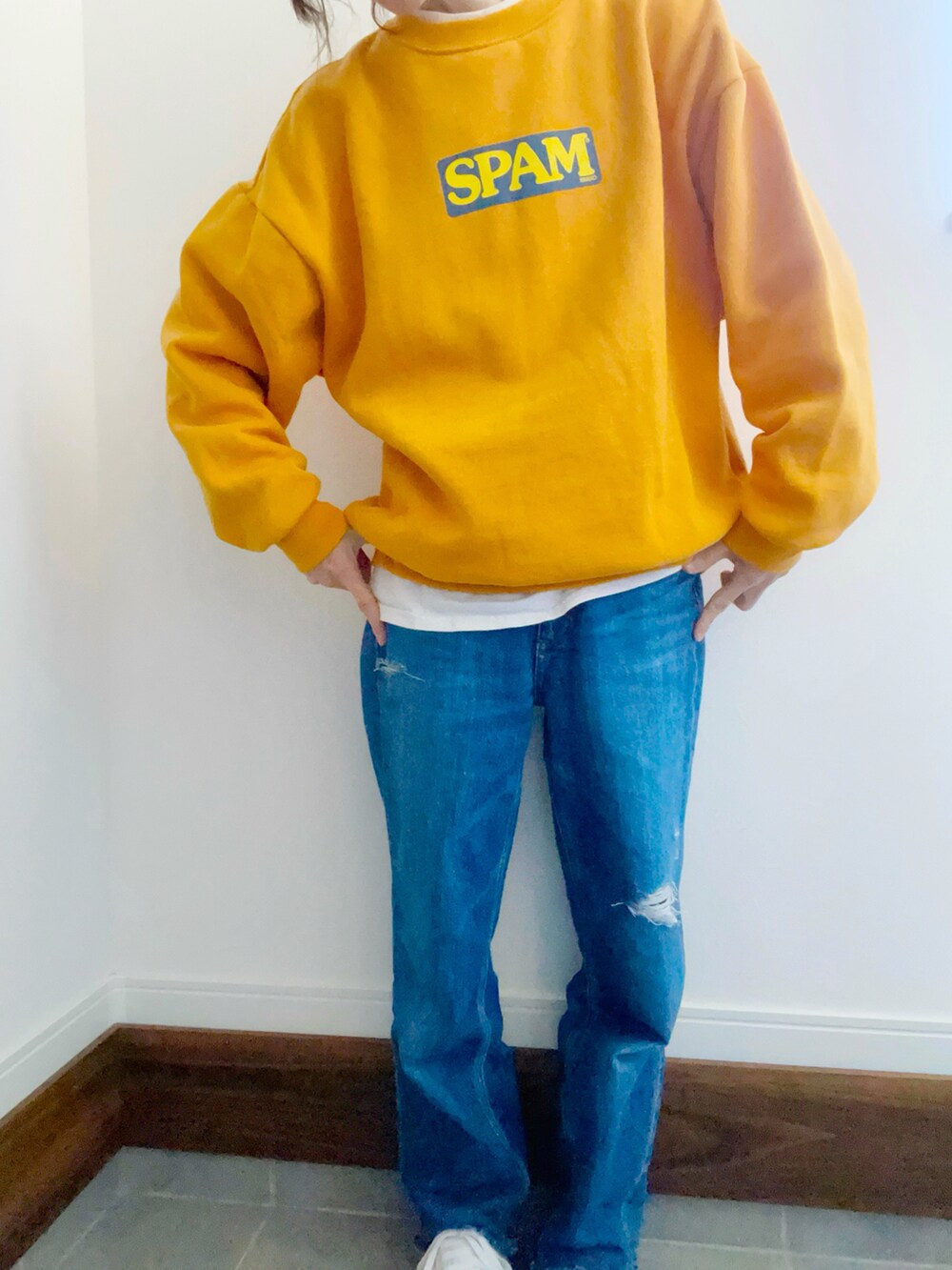 ブルー系のデニムパンツ、ホワイト系のスニーカー、イエロー系のスウェットを着用したレディースの冬コーディネートの4枚目の写真