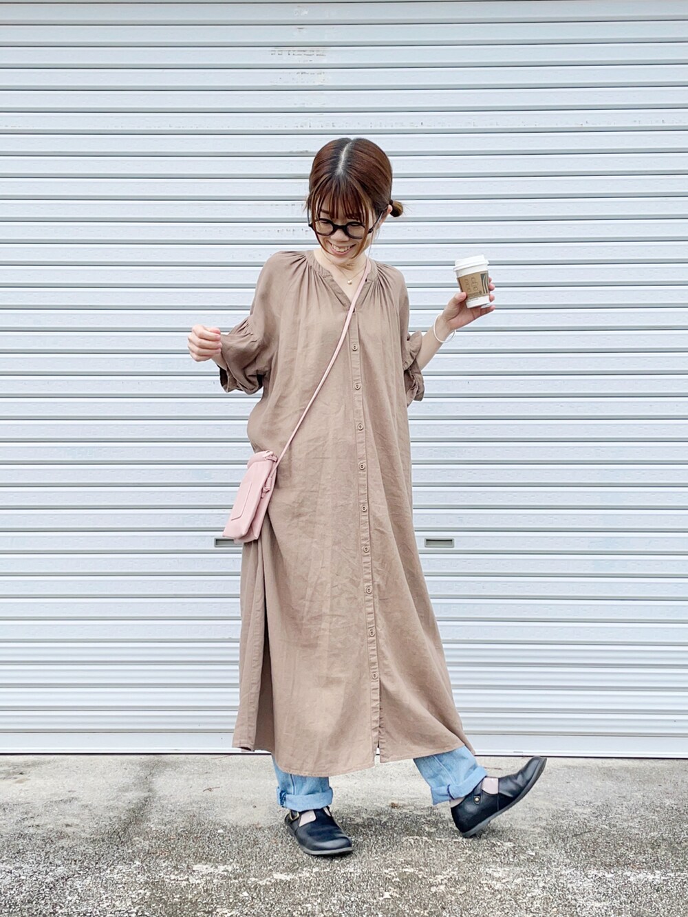 ブラック系のその他シューズ、ブルー系のデニムパンツ、ブラウン系のワンピースを着用したレディースの春コーディネートの2枚目の写真