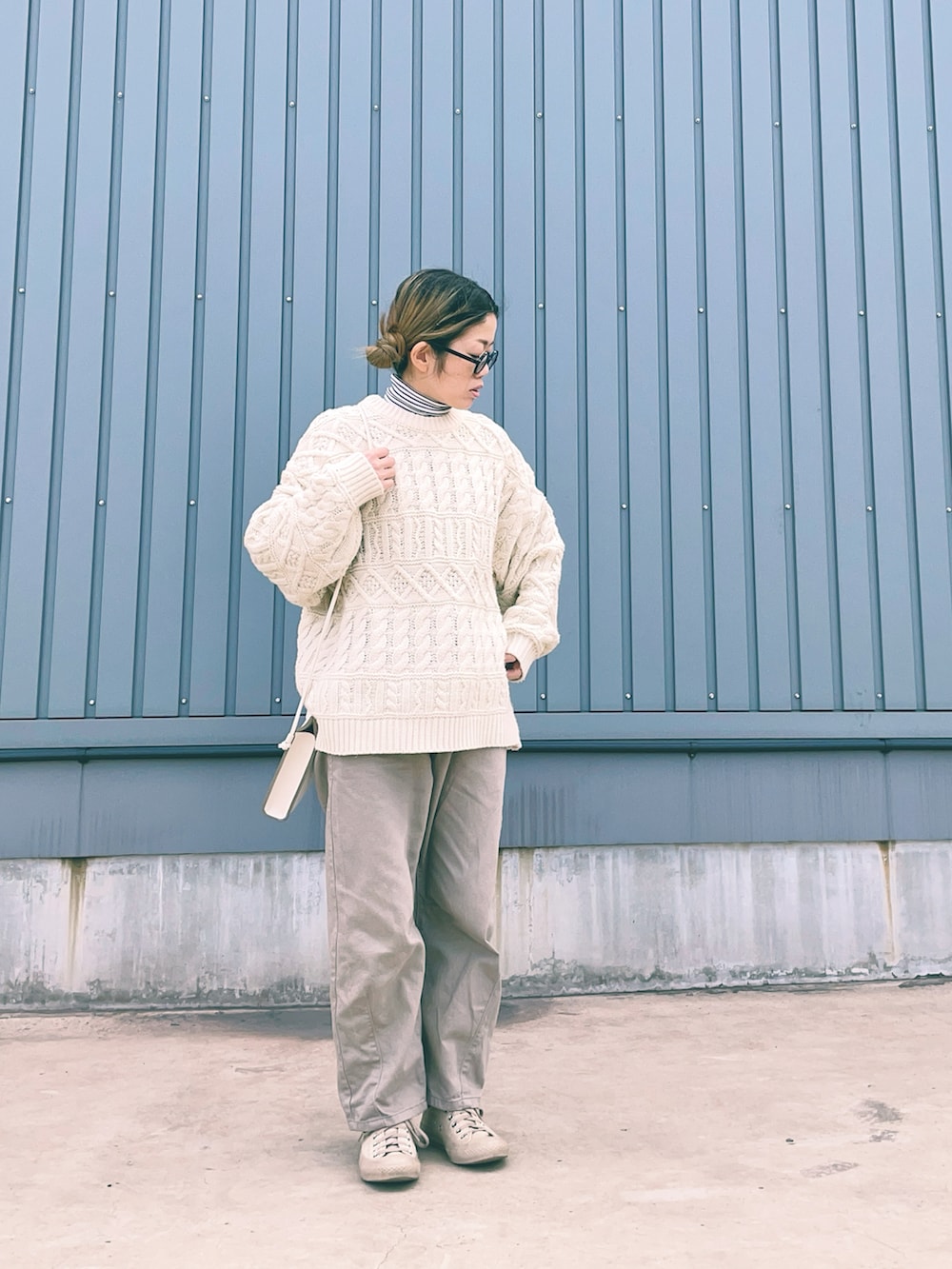 ベージュ系のスニーカー、ベージュ系のその他パンツ、ホワイト系のニット/セーターを着用したレディースの冬コーディネートの2枚目の写真