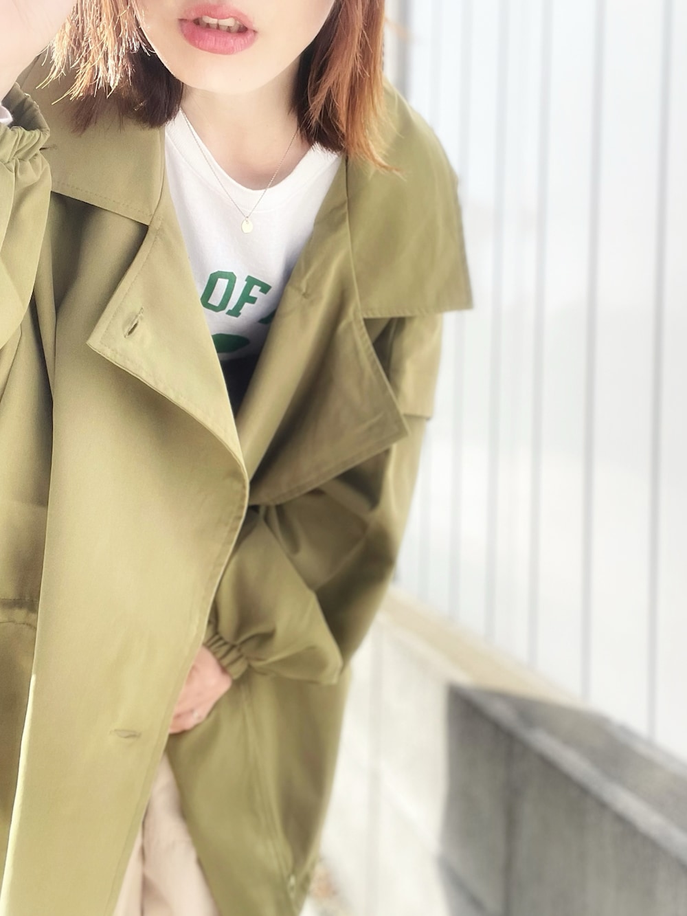 ベージュ系のカーゴパンツ、ホワイト系のTシャツ/カットソー、グリーン系のモッズコートを着用したレディースの春コーディネートの3枚目の写真