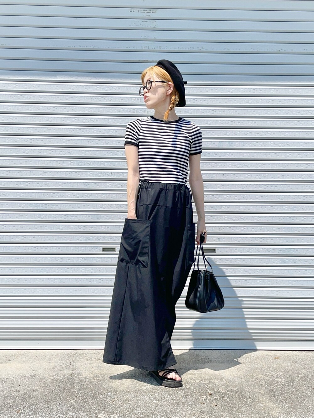 ブラック系のショルダーバッグ、ブラック系のTシャツ/カットソー、ブラック系のサンダルを着用したレディースの夏コーディネートの2枚目の写真