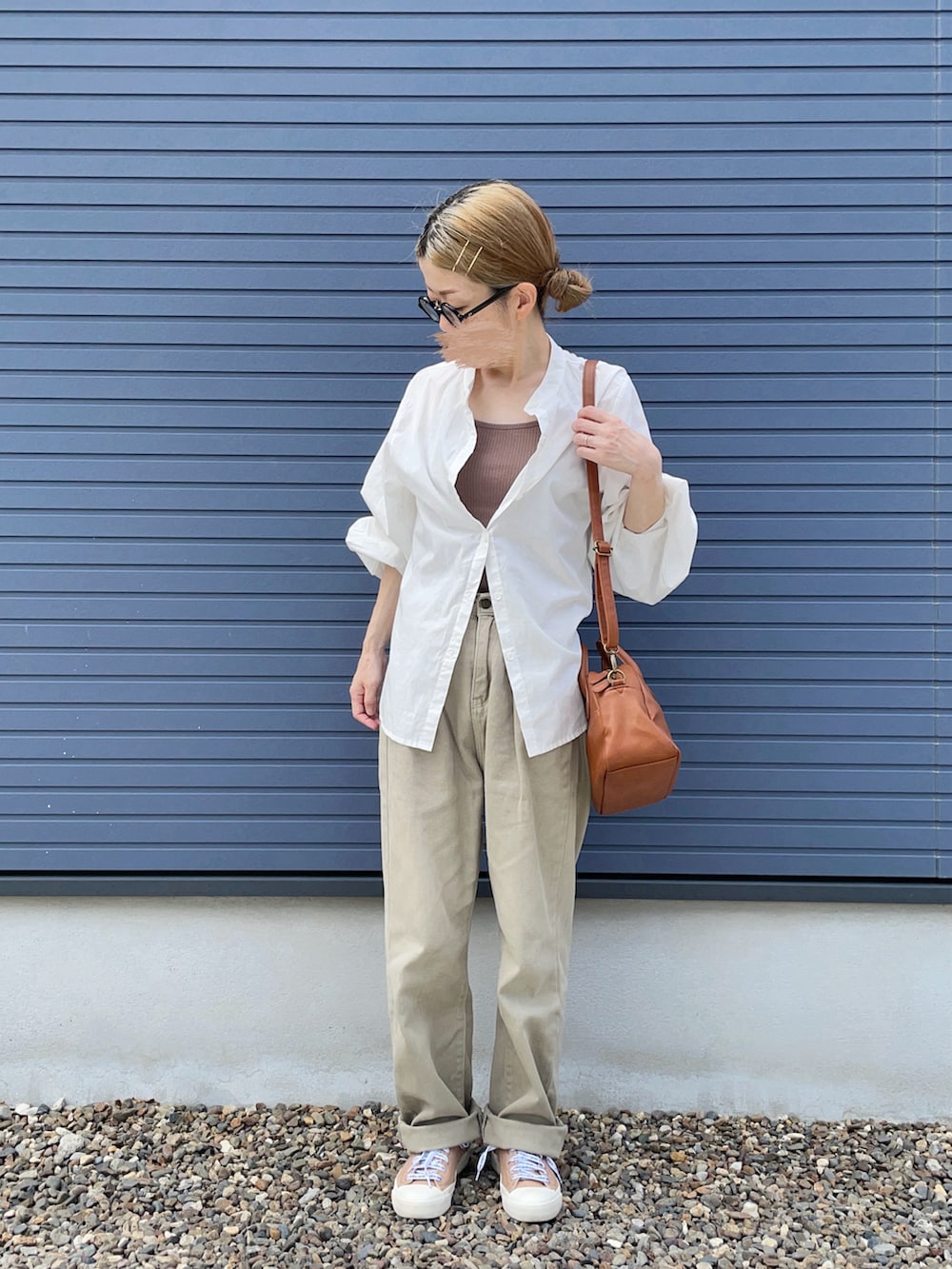 グリーン系のデニムパンツ、ベージュ系のスニーカー、イエロー系のショルダーバッグを着用したレディースの秋コーディネートの2枚目の写真