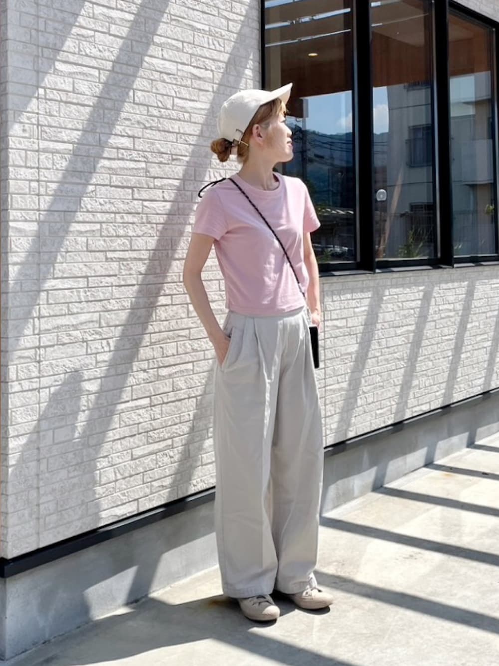 グレー系のその他パンツ、ピンク系のTシャツ/カットソー、ベージュ系のスニーカーを着用したレディースの夏コーディネートの2枚目の写真