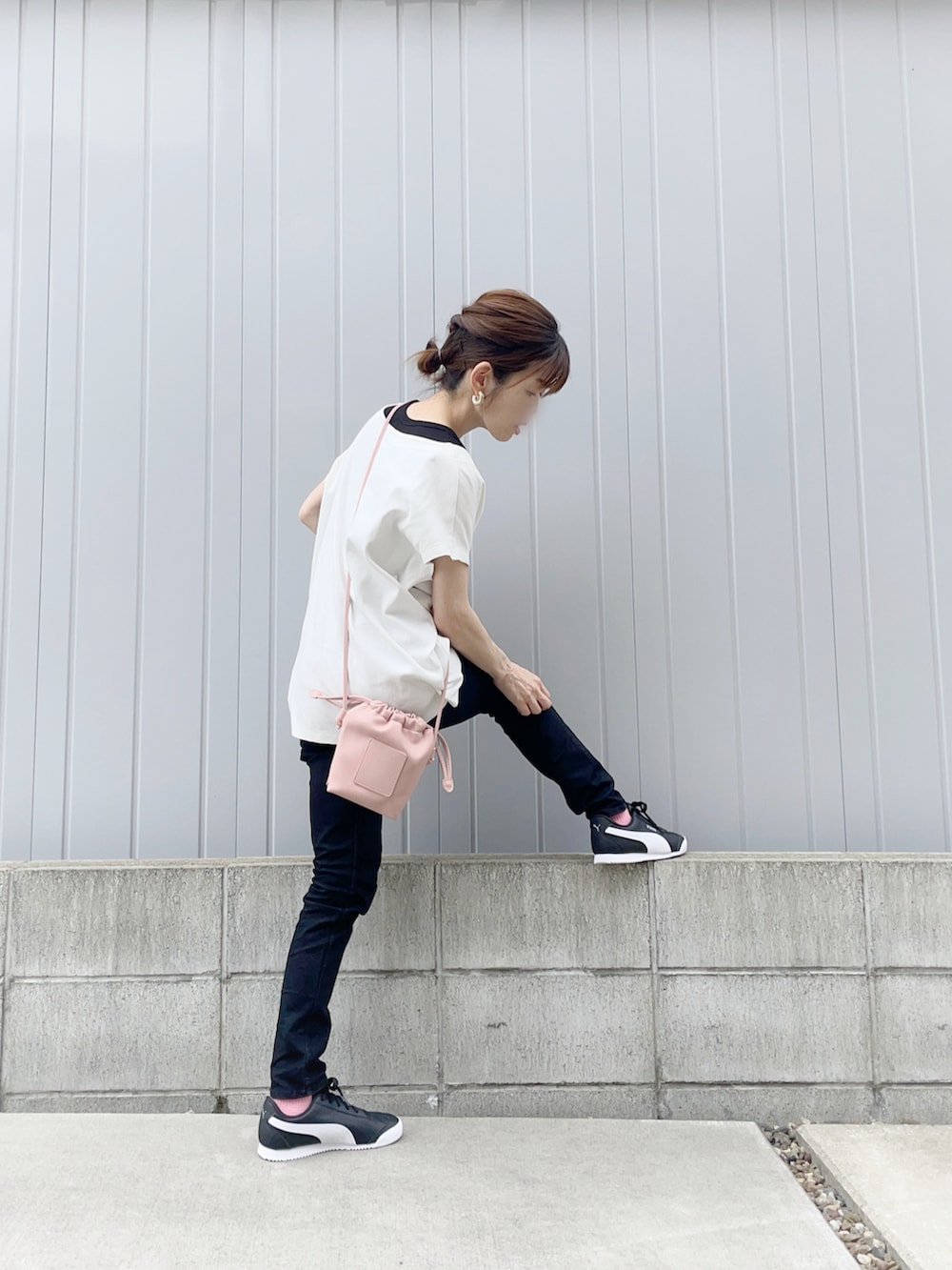 ブラック系のパンツ、ブラック系のスニーカー、ホワイト系のTシャツ/カットソーを着用したレディースの夏コーディネートの2枚目の写真